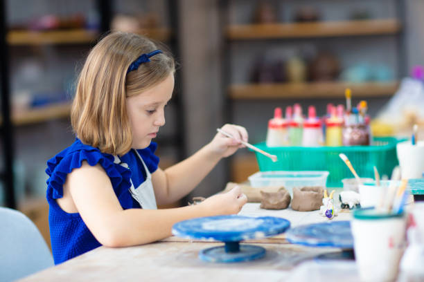 istock Child at pottery wheel. Kids arts and crafts class 2156861007