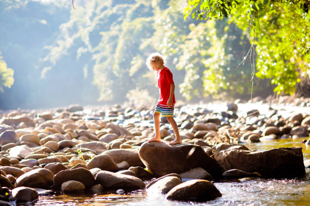 istock Child hiking in mountains. Kids at river shore. 2156861113