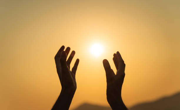 istock Closeup hands praying for blessing from god during sunset background. Hope and freedom concept. 2156863449