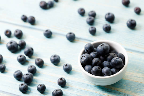 istock Ripe organic blueberries on blue wooden table background. Selective focus. 2156864076