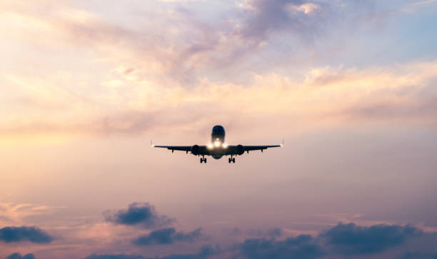 istock Airplane approaching for landing against dramatic sunset sky with clouds. Transportation, travel and adventure concept 2156869064