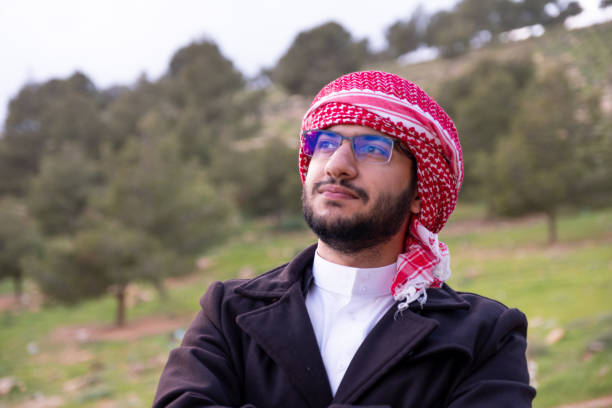 istock An Arab man in nature clears his mind and thinks positively about the future, surrounded by trees and clouds wearing a jacket due to change in climate 2156869918