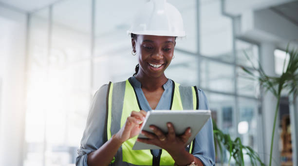 Female engineer, tablet and browsing with smile for construction or project management with tech. Planning, safety and research for industrial manufacturing or maintenance in modern office