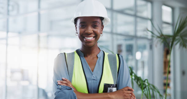 istock Construction worker, portrait and black woman with arms crossed for confidence, engineering or project management. Smile, contractor and person for maintenance, building renovation or architecture 2156870140