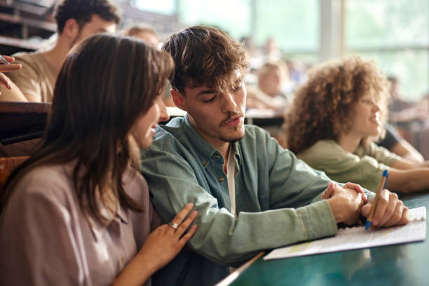 istock Young college couple having a class at lecture hall. 2156871736