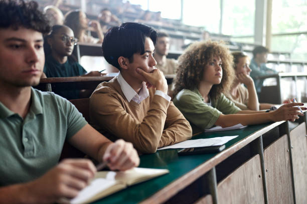 istock Pensive Japanese student on a class at lecture hall. 2156871810