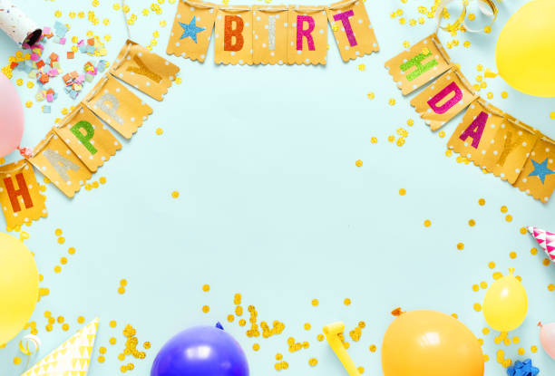 Frame of paper party flags with decoration birthday partyon a pastel blue background with copy space top view