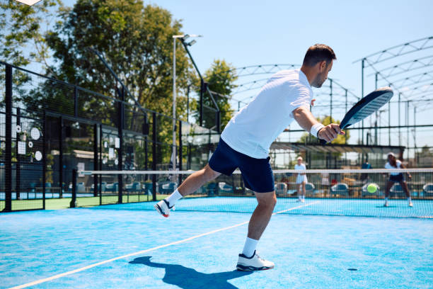 istock Athletic man hitting the ball while playing paddle tennis on the court. 2156875104