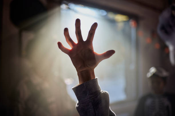 Close up of unrecognizable woman's scary hand over foggy window on Halloween.