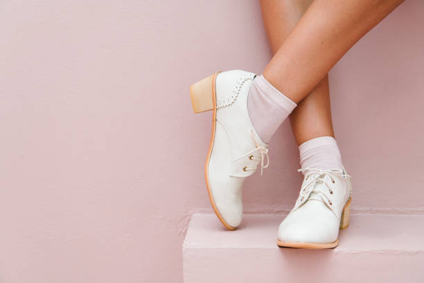 istock Crossed legs wearing white oxford shoes 2156879804
