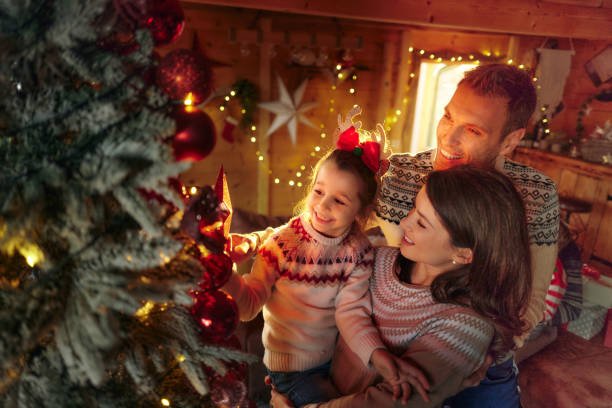 istock Happy family decorating Christmas tree at home. 2156881305