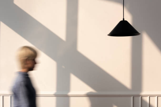 istock Woman walking past a pendant lamp 2156881396