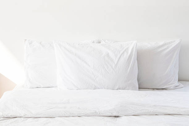 istock White bed linen on a bed in a white bedroom 2156882331