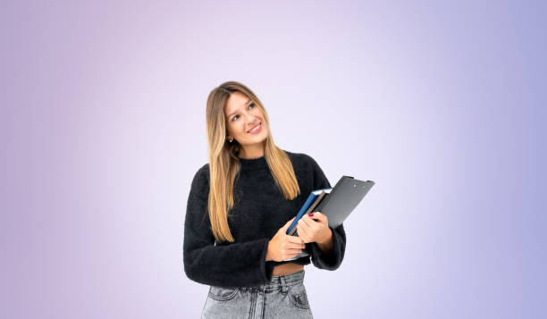 istock Woman student with clipboard and notebook in hands, copy space 2156882390