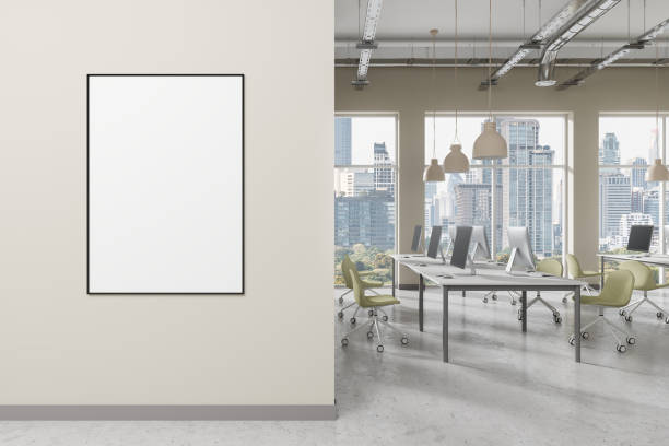 istock An office interior with a blank poster on a wall and computers on desks, light. Concept of workspace design.  3D Rendering 2156882870