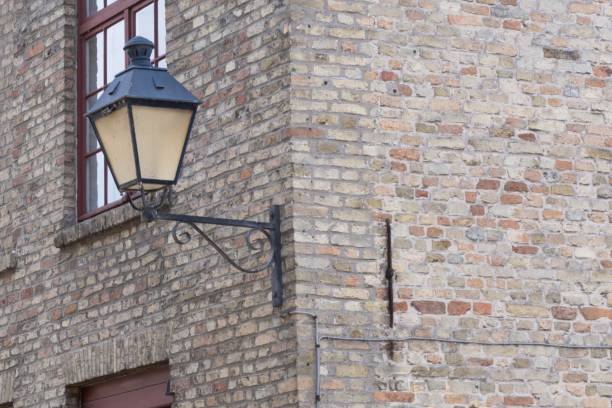 Lantern on a gray brick wall entwined with ivy