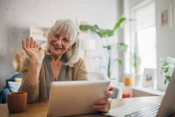 istock Senior white woman using a digital tablet and talking on video chat 2156887367