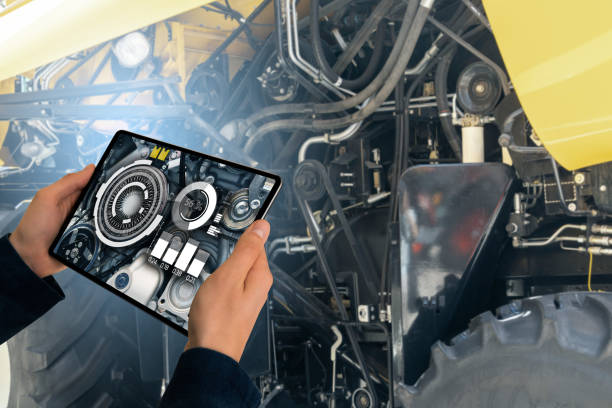 istock Serviceman with digital tablet next to combine harvester with open hood. 2156888095