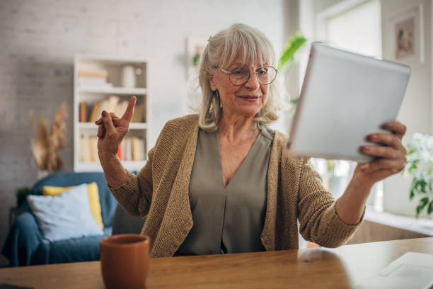 istock Senior white woman using a digital tablet and talking on video chat 2156888258