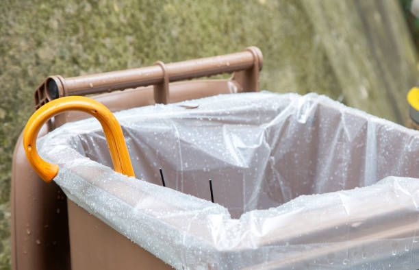 istock Big plastic rubbish container with opened cover white plastic bag inside and a broken umbrella. Ecological contest. separate waste collection 2156889222