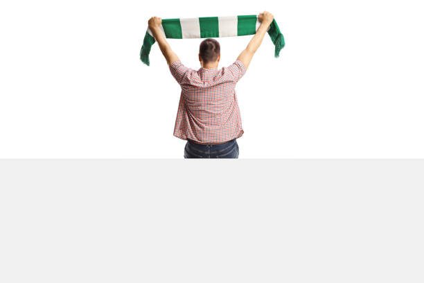 istock Rear view shot of a man holding a scarf sitting on a panel and cheering 2156890225