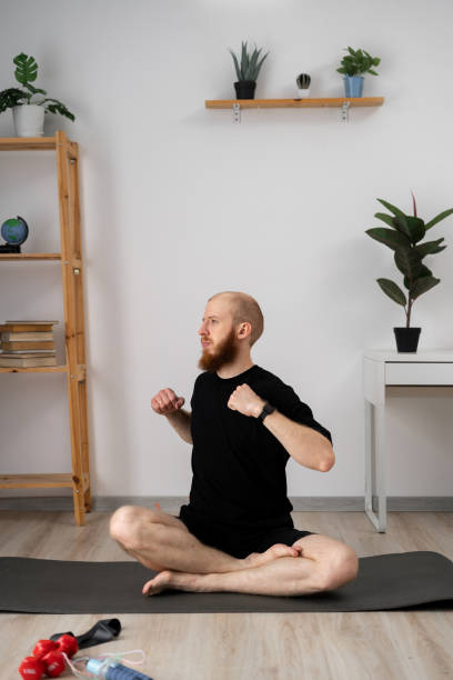 istock A man is practicing yoga in his home studio, focusing on stretching and meditating on a mat 2156890771