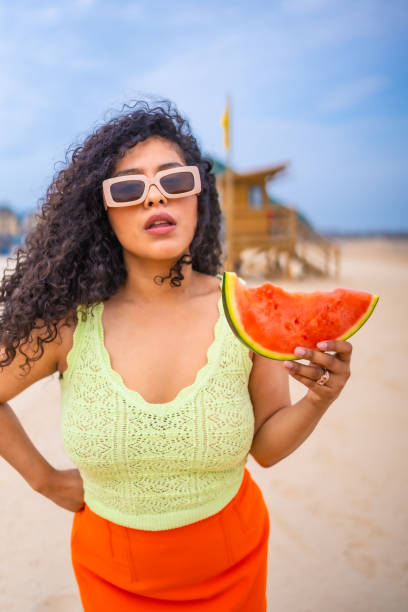 istock A woman is holding a watermelon on a beach 2156891205