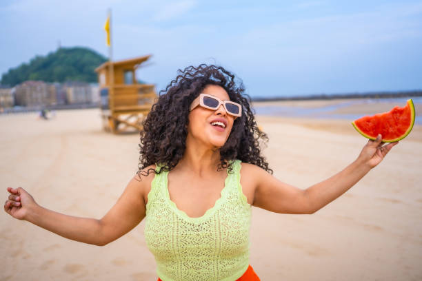 istock A woman is holding a watermelon on a beach 2156891206