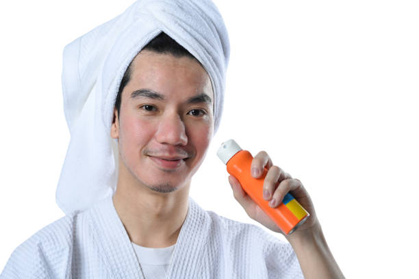 istock Smiling young man holding spray bottle of sunscreen isolate on white background 2156895591
