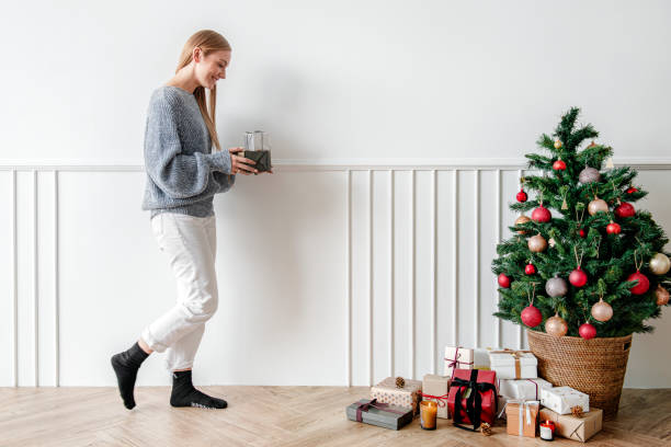istock Blond girl decorating a Christmas tree with presents 2156895734