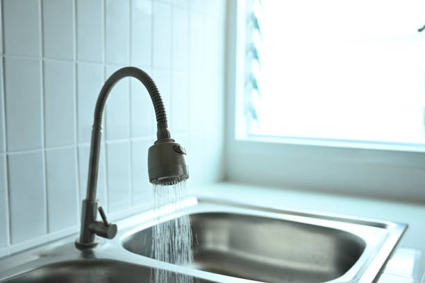 istock Chrome faucet with running water in the kitchen 2156896092