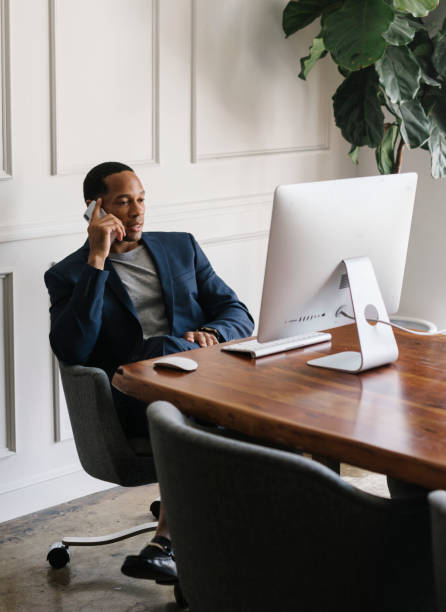 istock Casual businessman talking on a phone while working in the office 2156896780