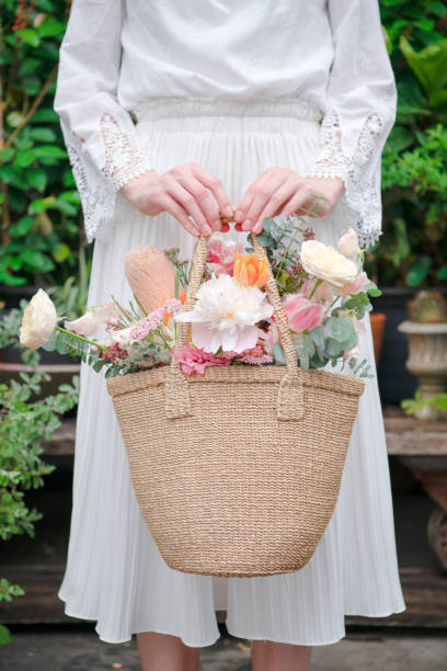 istock Woman carrying flowers in a wicker bag 2156896826