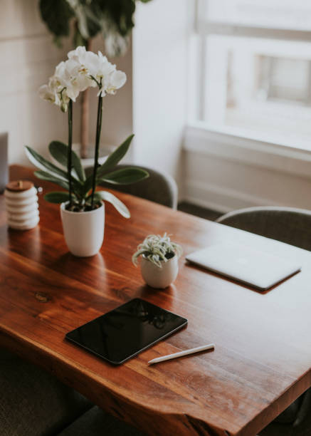 Digital tablet and a laptop on a wooden table in the office