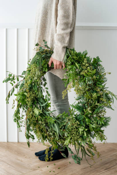 istock Woman carrying a fresh Christmas wreath 2156899062