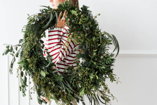 istock Woman carrying a fresh Christmas wreath 2156899065