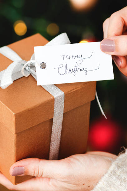 istock Woman holding a brown present with a white card 2156899180