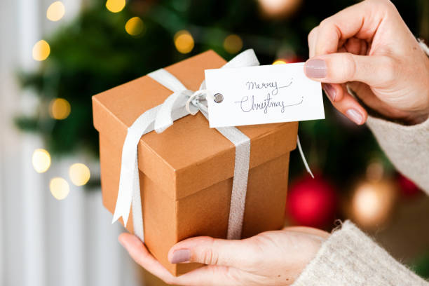 istock Woman holding a brown present with a white card 2156899181
