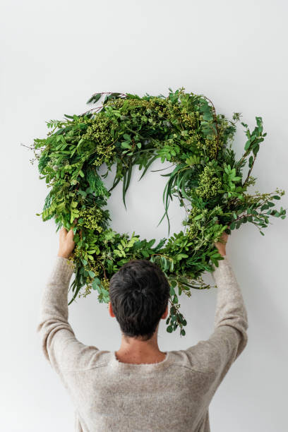 istock Woman hanging a fresh Christmas wreath 2156899224