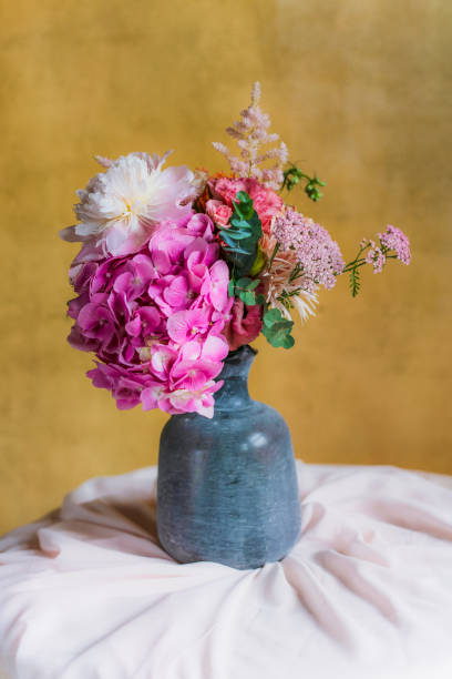 istock Flowers in a vase by a yellow wall 2156900442