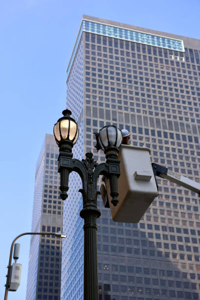 istock Municipal worker changing a lightbulb to the antique streetlight 2156903617