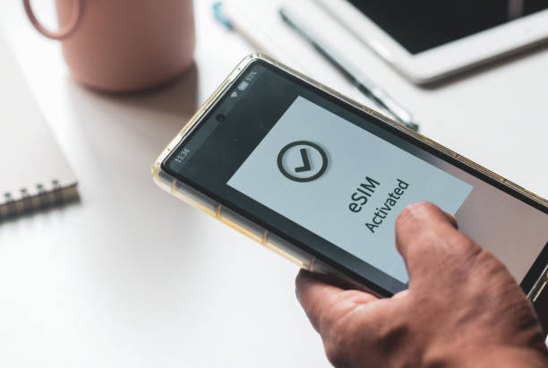 istock Advantage of eSIM connection for network services concept. A person's mobile phone displaying the message eSIM activated successfully. 2156905231