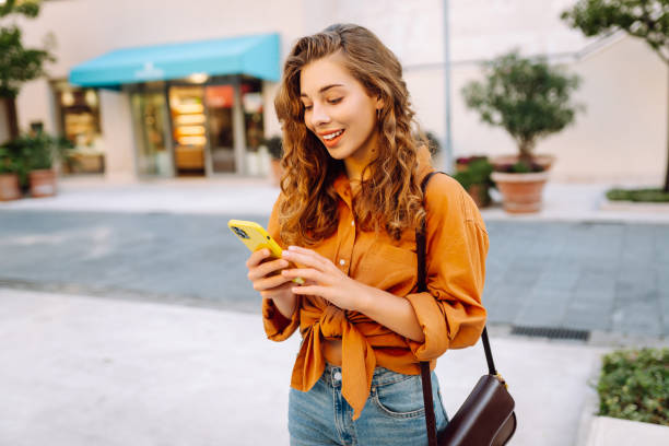 istock Happy woman using smartphone, texting messages a mobile phone, communicate in city 2156907895