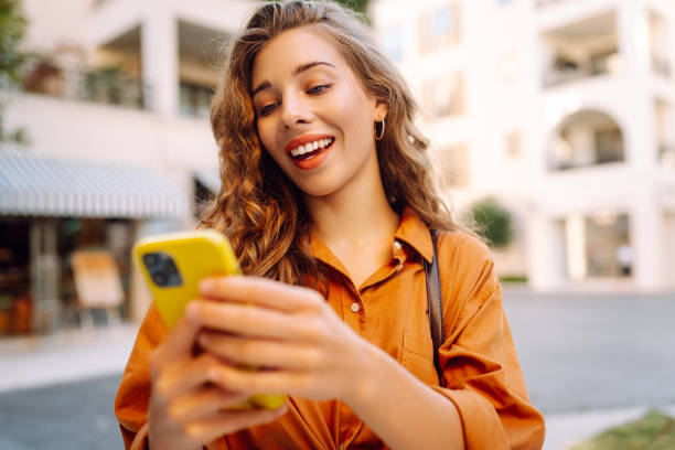 istock Happy woman using smartphone, texting messages a mobile phone, communicate in city 2156908185