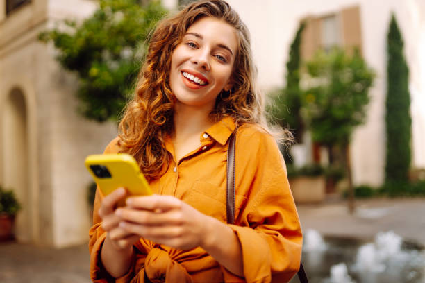 istock Happy woman using smartphone, texting messages a mobile phone, communicate in city 2156908304