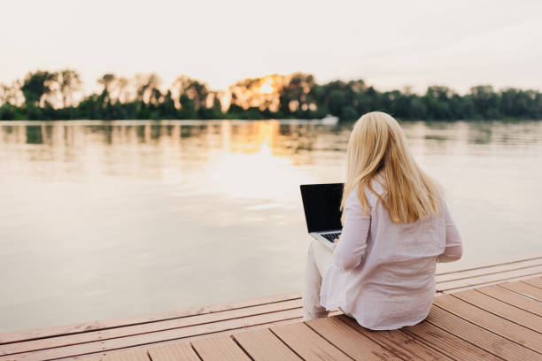 istock One mid adult woman using laptop 2156909957