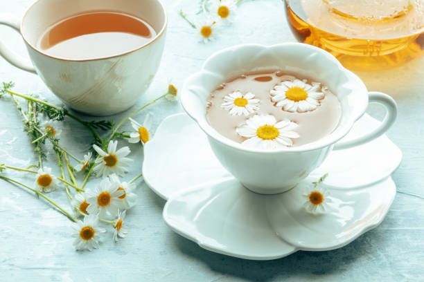 istock Chamomile flower tea. A tea cup and a tea pot with fresh medicinal flowers 2156911469