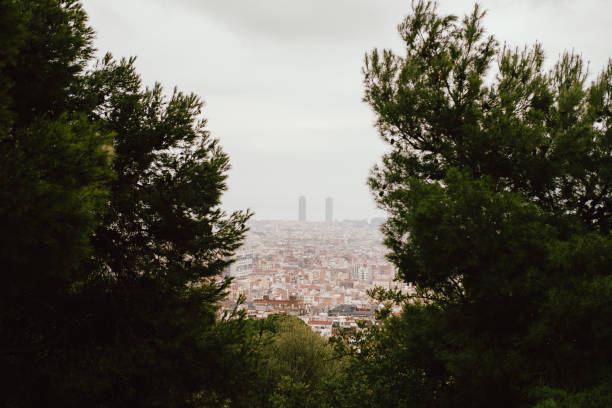 A picturesque cityscape is visible through lush greenery, blending city life with nature harmoniously