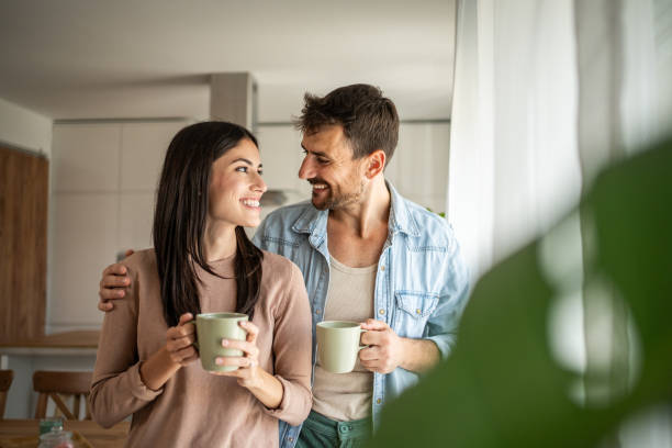 istock Young couple looking through the window in their home 2156914588