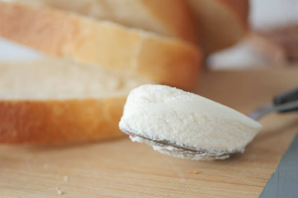 Slice of bread and cream cheese on white background